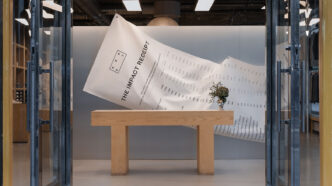 Campaña de Asket instalada en una tienda que muestra el ticket del impacto en la compra de una prenda