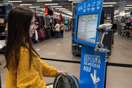 Clienta de Decathlon pasando sus productos por la caja automática
