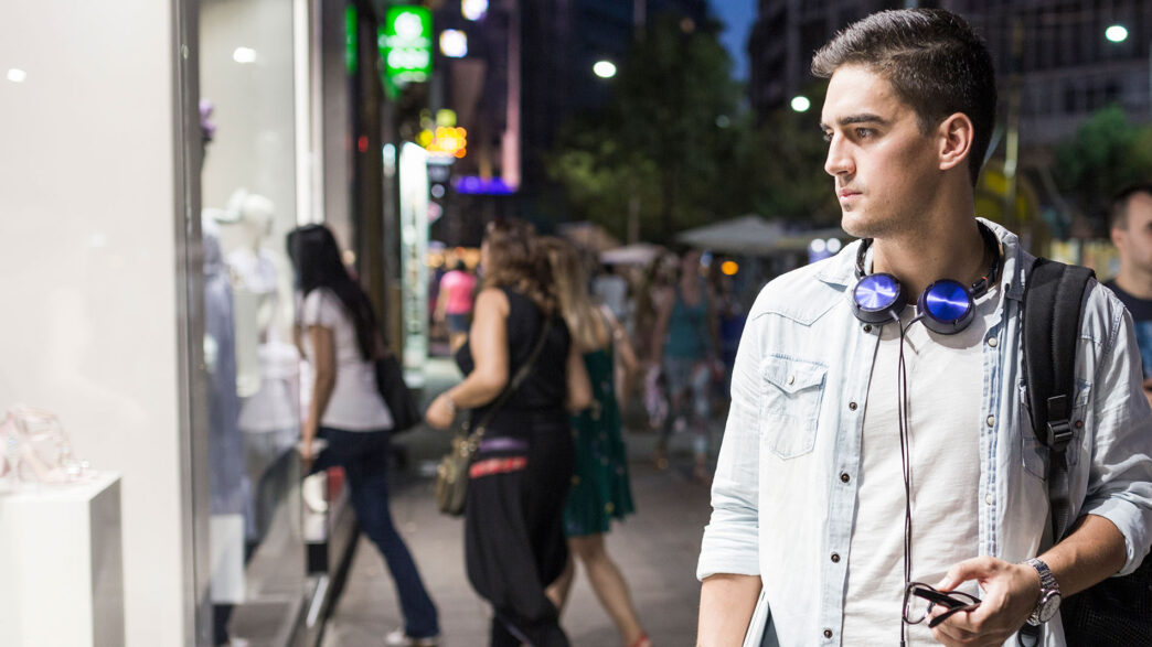 Joven de la generación Z mirando a un escaparate de una tienda