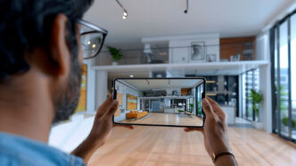 Chico mirando a un espacio a través de su móvil con un app para decorar virtualmente