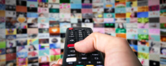 Persona pulsando botones de un mando de televisión