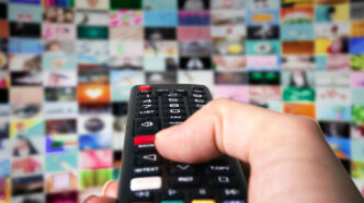Persona pulsando botones de un mando de televisión
