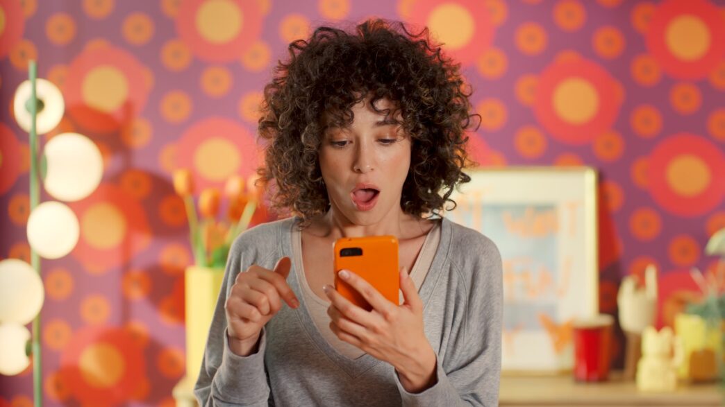 Chica viendo su móvil en una campaña de Temu