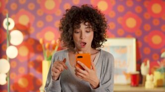 Chica viendo su móvil en una campaña de Temu