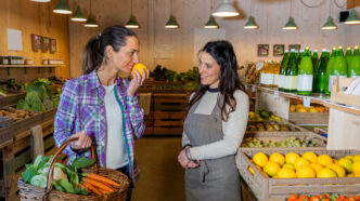 Una chica comprando fruta y verdura en una tienda local