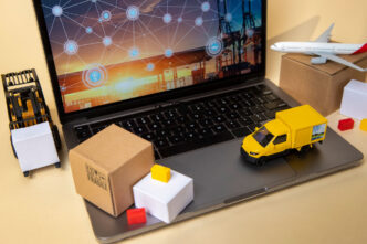 Un camión, un avión y cajas en miniatura sobre un portátil para simbolizar el cash&carry