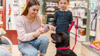 Madre con un niño y su perro en una tienda de artículos para las mascotas