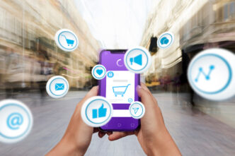 Unas manos sujetan un móvil del que salen iconos relacionados con el retail media