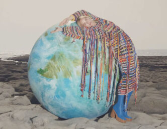 Modelo de Stella McCartney sobre una bola del mundo