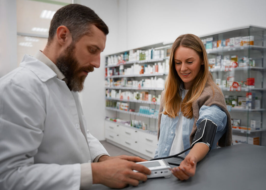 Farmacéutico tomándole la tensión a una chica