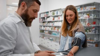 Farmacéutico tomándole la tensión a una chica