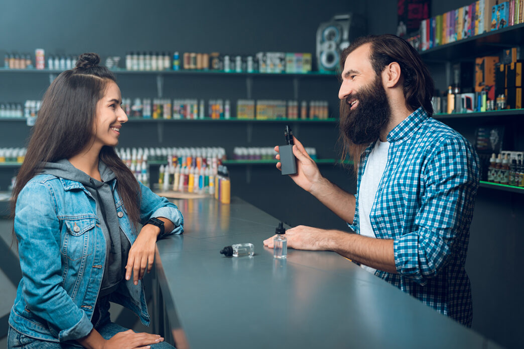 Chica comprando vape en un estanco