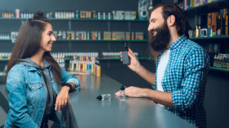 Chica comprando vape en un estanco